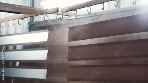 The human hand with dexterous movements paints the metal sheet with a paint gun
