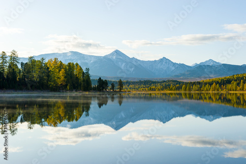 lake, Altai, autumn day. Taiga, beautiful sky, mountains and mountain reflections in the lake.