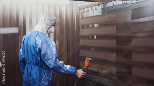 Spraying brown powder paint on metal
