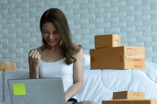 Asian women working with laptop for Online shopping at home with box for packaging in home,Own Small Business Start up for Online shopping.Small business concept.