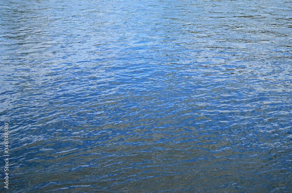 Water surface with ripples and sunrays reflections Water surface with ripples and sunrays reflections