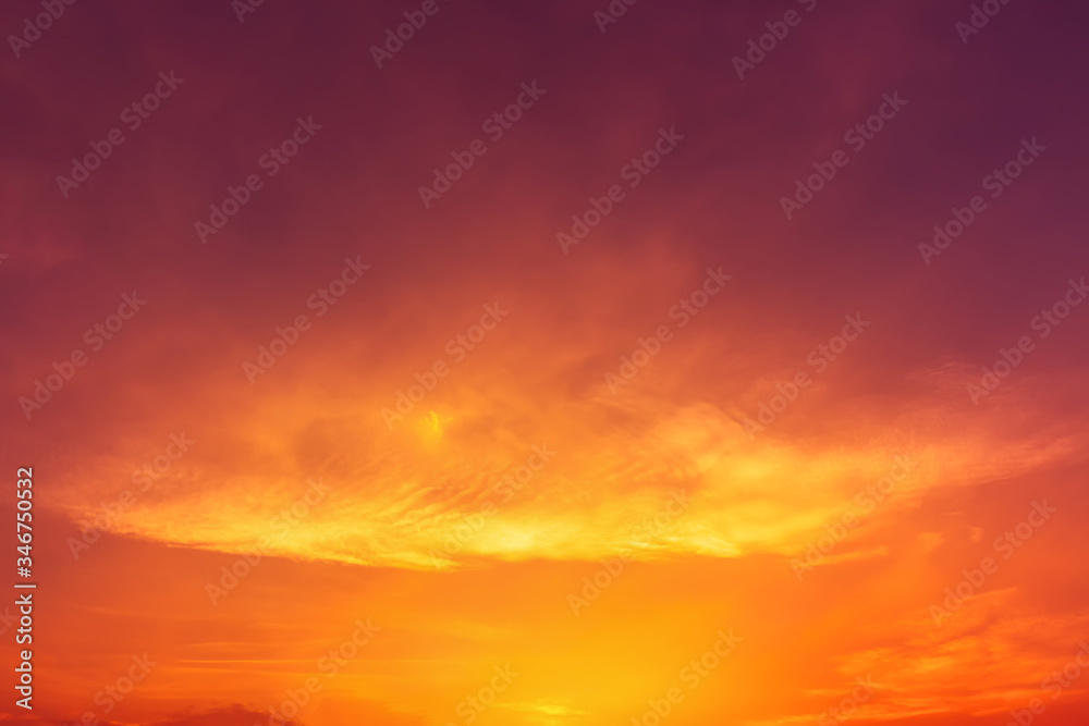 Dark red sky with orange and yellow light with blurred clouds