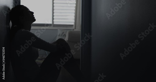 Sad, tired girl sitting alone in bedroom 
