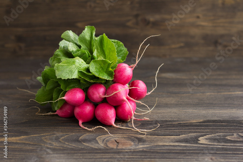 Bunch of fresh red radish on wooden background, free space, selective focus