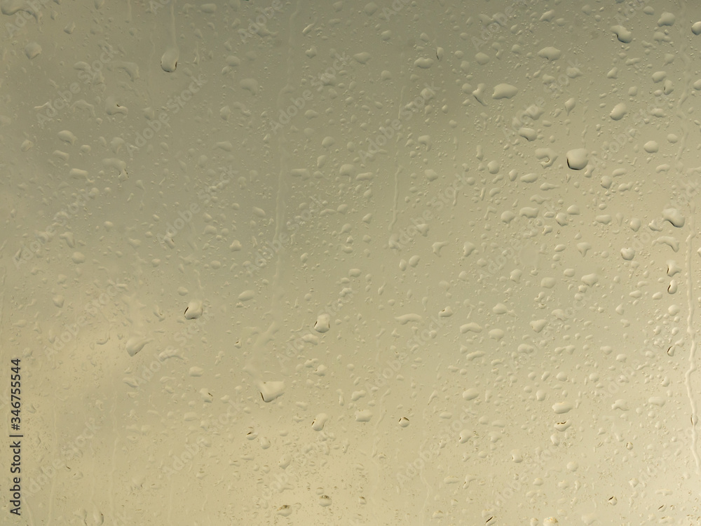 Wet window with rain drops and a cloudy sky outside. Wet window with rain drops and a cloudy sky outside.