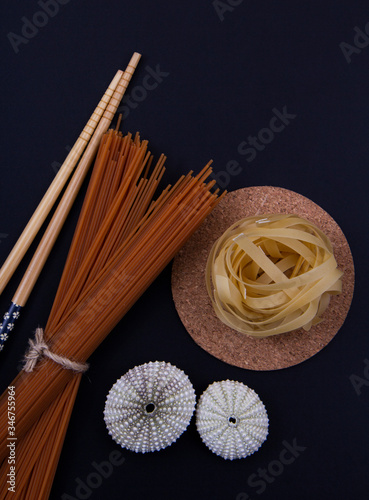 Chopsticks, linguine pasta and sea urchin shells. photo