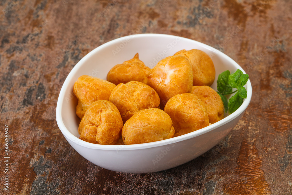 Sweet tasty profiteroles heap in the bowl Sweet tasty profiteroles heap in the bowl