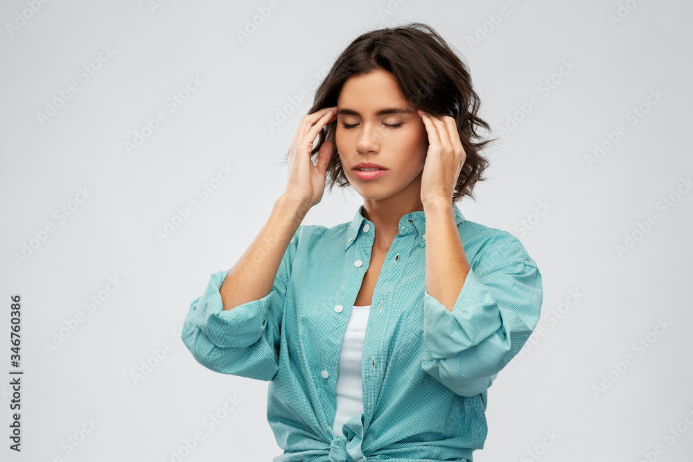 stress, health and people concept - young woman having headache holding to her head over grey background stress, health and people concept - young woman having headache holding to her head over grey background