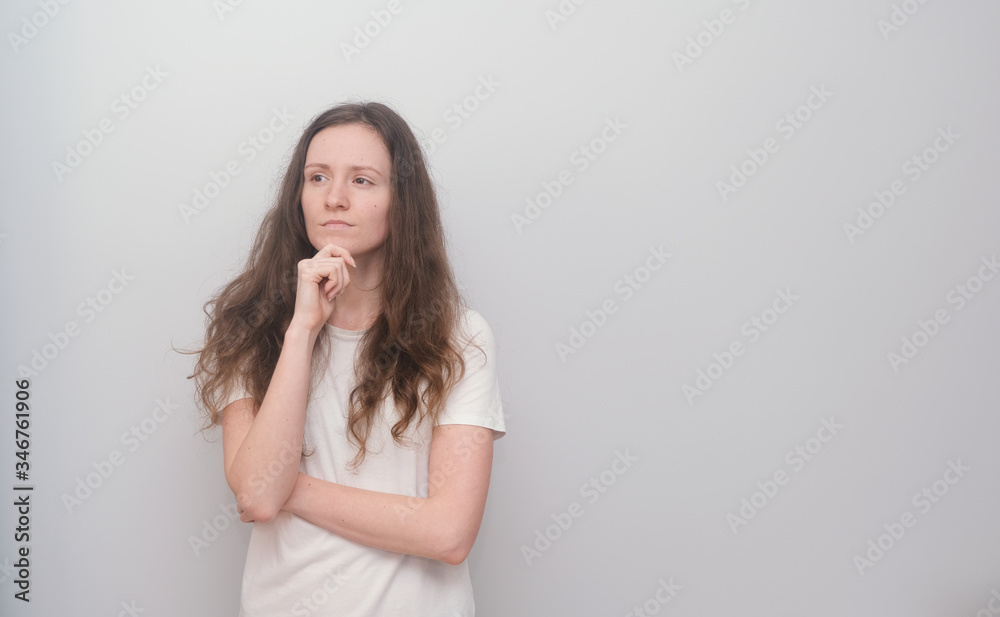 Young and beautiful girl wearing white T-shirt on grey background. Young and beautiful girl wearing white T-shirt on grey background.