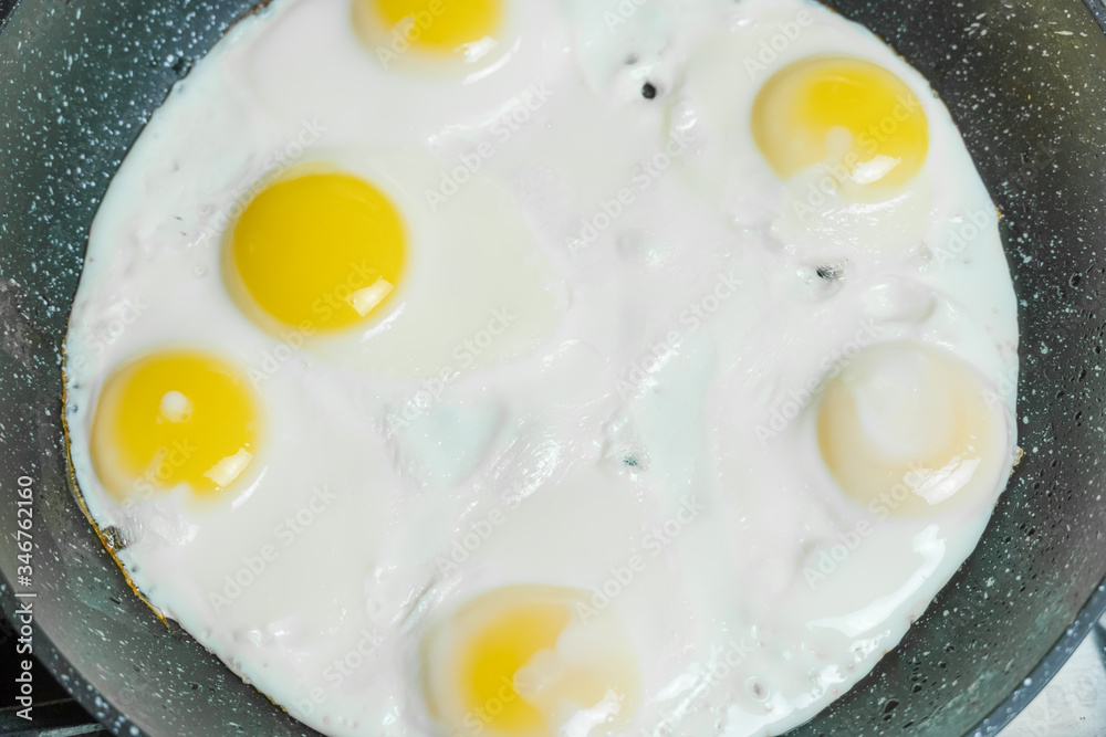 Six eggs in close-up frying in a pan on a gas stove, top view Six eggs in close-up frying in a pan on a gas stove, top view