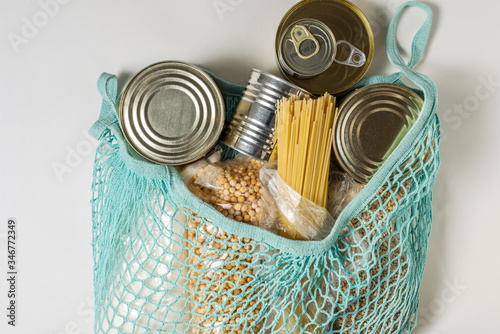 String bag with long-term storage products on a white background. Food donations or the concept of food delivery during quarantine