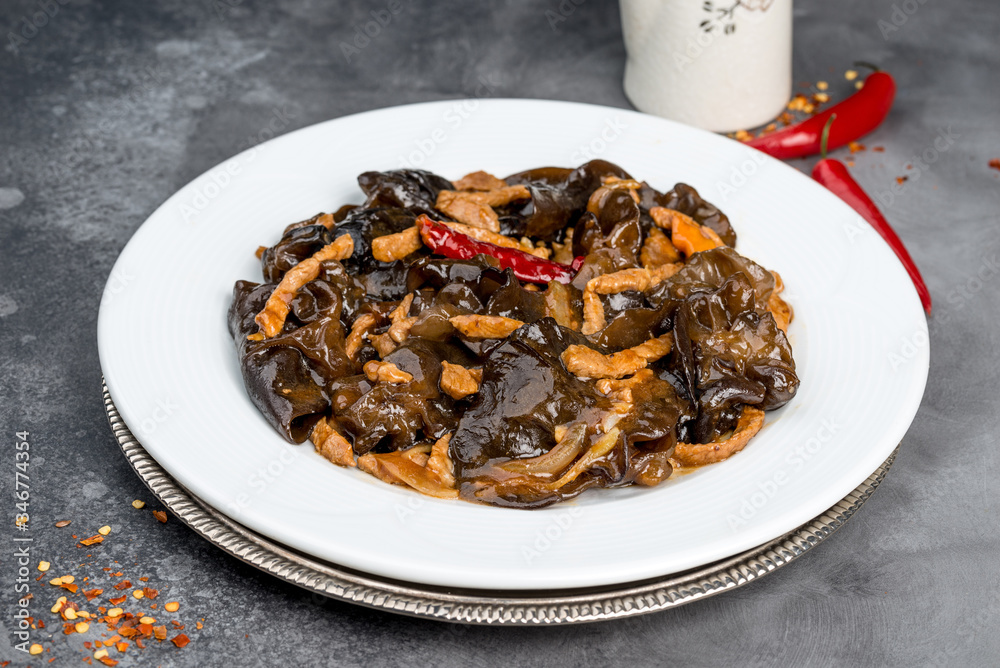 Wood mushrooms with meat in a white plate on a gray background Wood mushrooms with meat in a white plate on a gray background