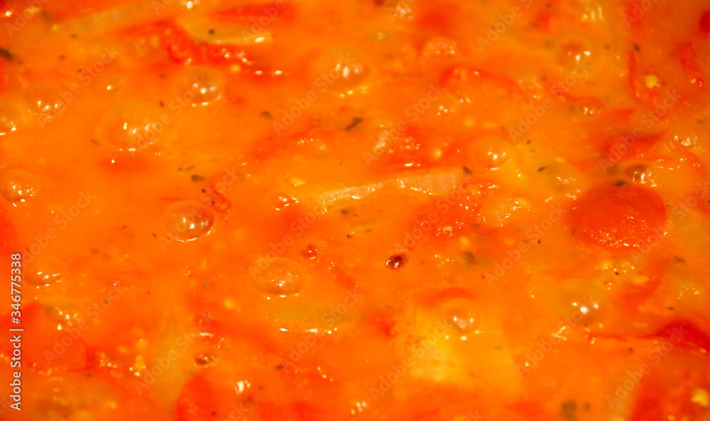 Preparación de salsa de tomate cherry. Salsa burbujeando por efecto del calor. Tomate, cebolla y orégano friéndose en aceite de oliva. Cocina española. Cocina mediterránea. Preparación de salsa de tomate cherry. Salsa burbujeando por efecto del calor. Tomate, cebolla y orégano friéndose en aceite de oliva. Cocina española. Cocina mediterránea.