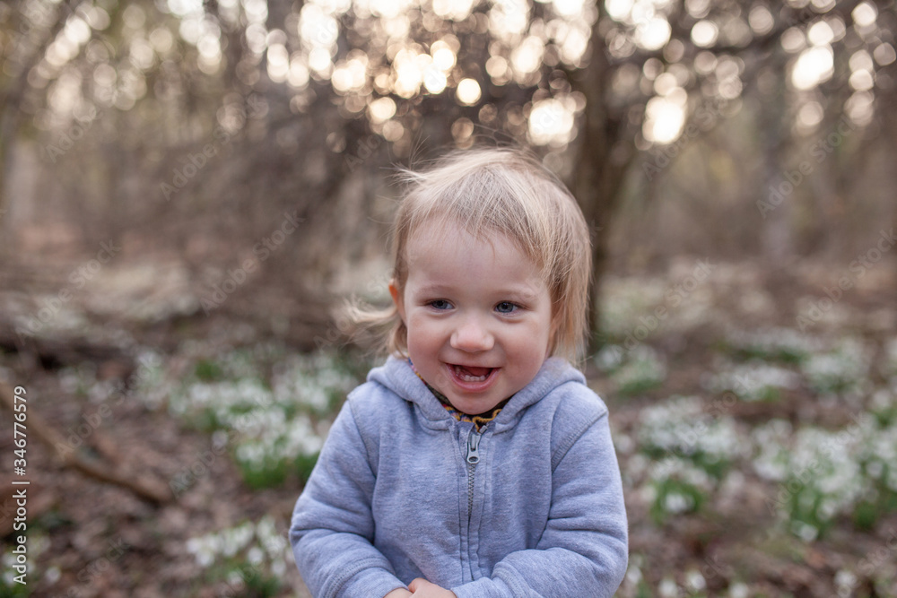 Little pretty girl in a clearing of snowdrops. A child walks in the spring forest. Little pretty girl in a clearing of snowdrops. A child walks in the spring forest.