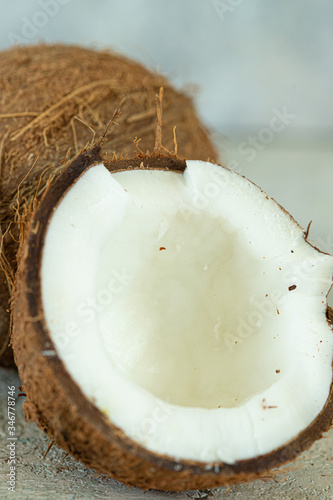 whole and a half coconuts close up vertical
