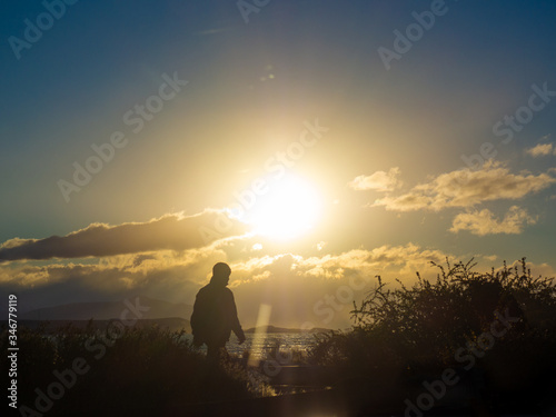 silhouette of a man walking in the setting sun 