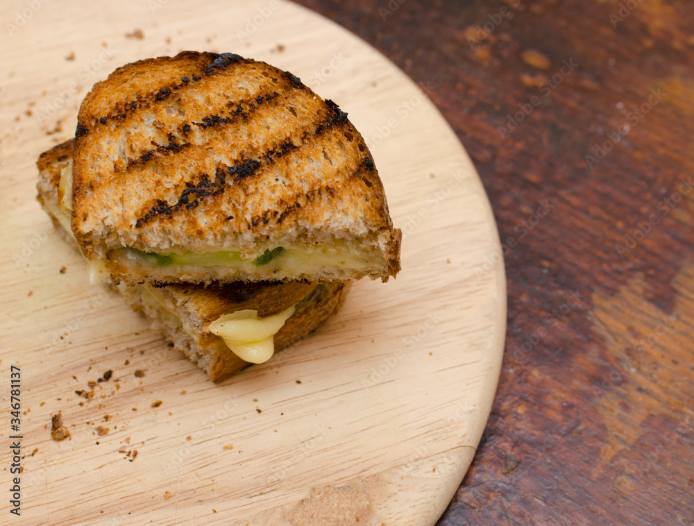grilled sandwich with cheese and cucumber on a wooden tray grilled sandwich with cheese and cucumber on a wooden tray