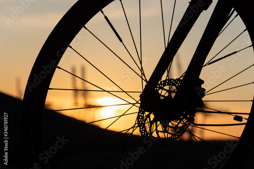 Profile of a bicycle wheel with disc brakes at sunset.