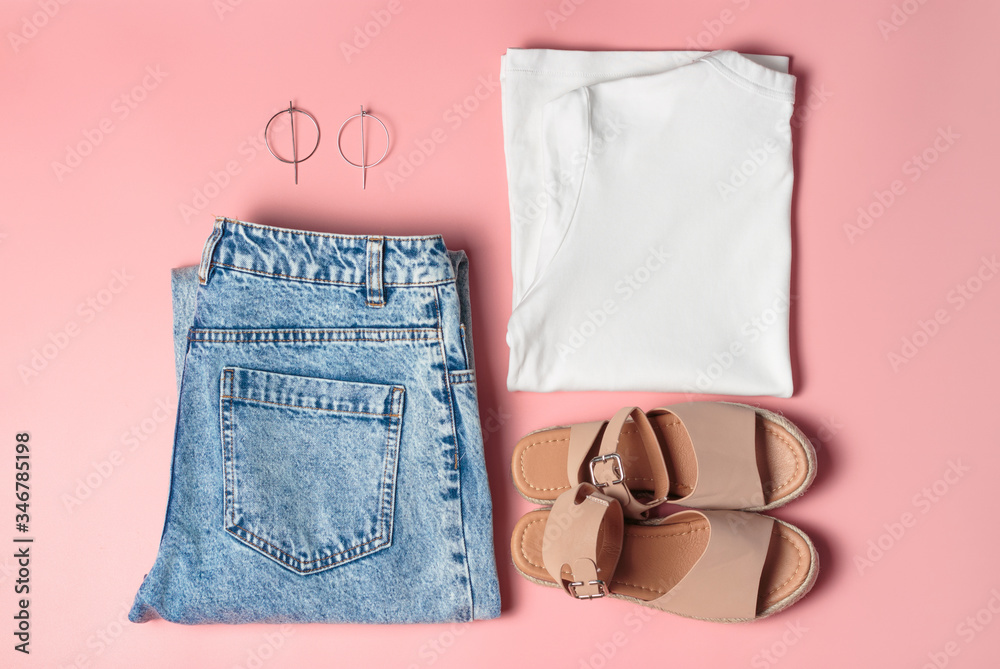 Set of women's fashion for the summer, the view from above. Jeans, white T-shirt, bag and sandals on pink background Set of women's fashion for the summer, the view from above. Jeans, white T-shirt, bag and sandals on pink background
