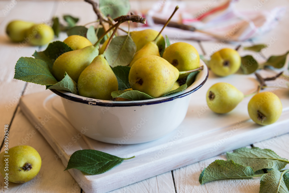 Fresh organic pears with leaves on white wooden background Fresh organic pears with leaves on white wooden background