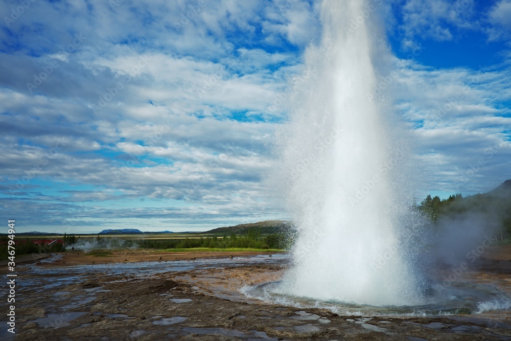 Geyser eruption with cloudy blue skies Geyser eruption with cloudy blue skies