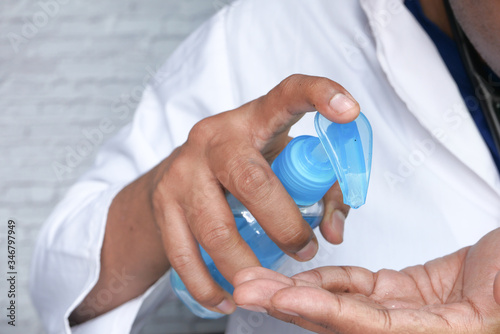 Close up of doctor hand using sanitizer for preventing virus 