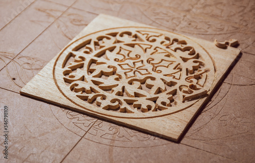 CNC machine has yet routed wood for cutting an oud / guitar hole cover cage away