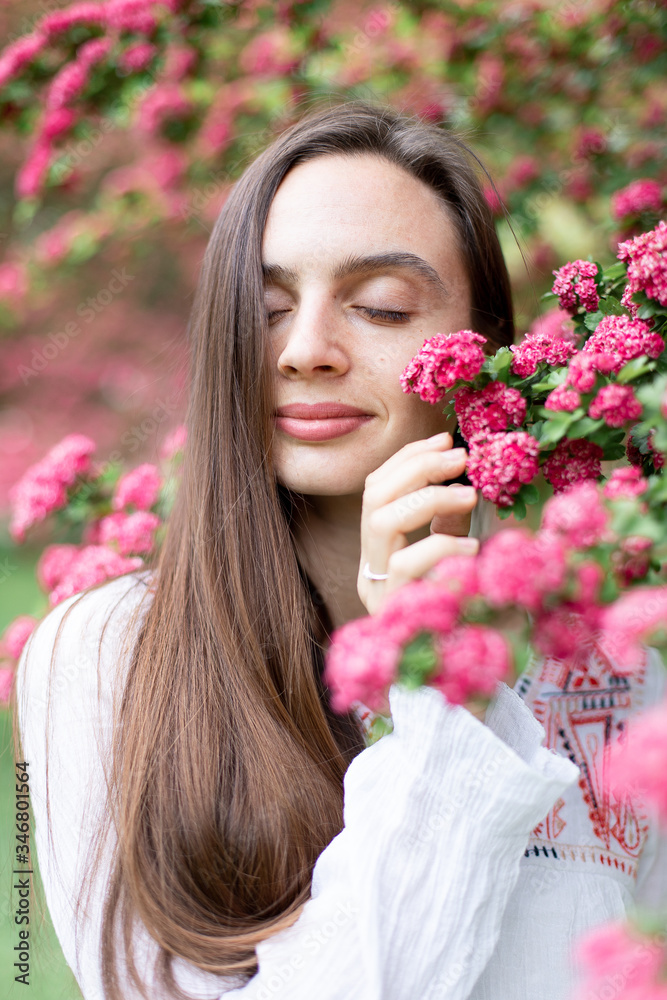 Portrait of a beautiful girl in a flowering pink tree. Flowering hawthorn tree Portrait of a beautiful girl in a flowering pink tree. Flowering hawthorn tree