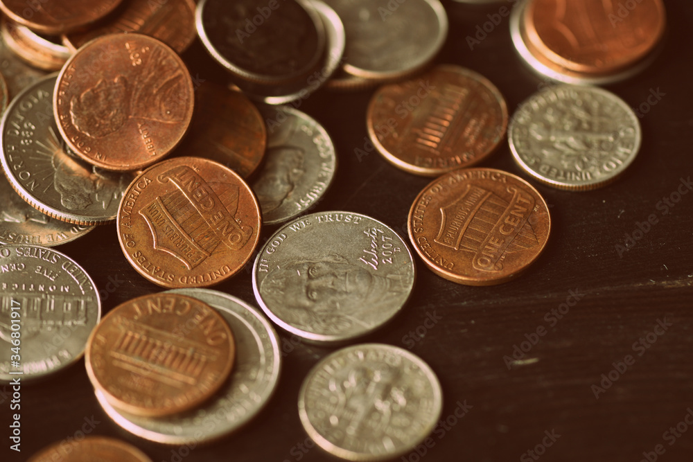American cents are scattered on an old black wooden surface close-up. Retro style toned American cents are scattered on an old black wooden surface close-up. Retro style toned