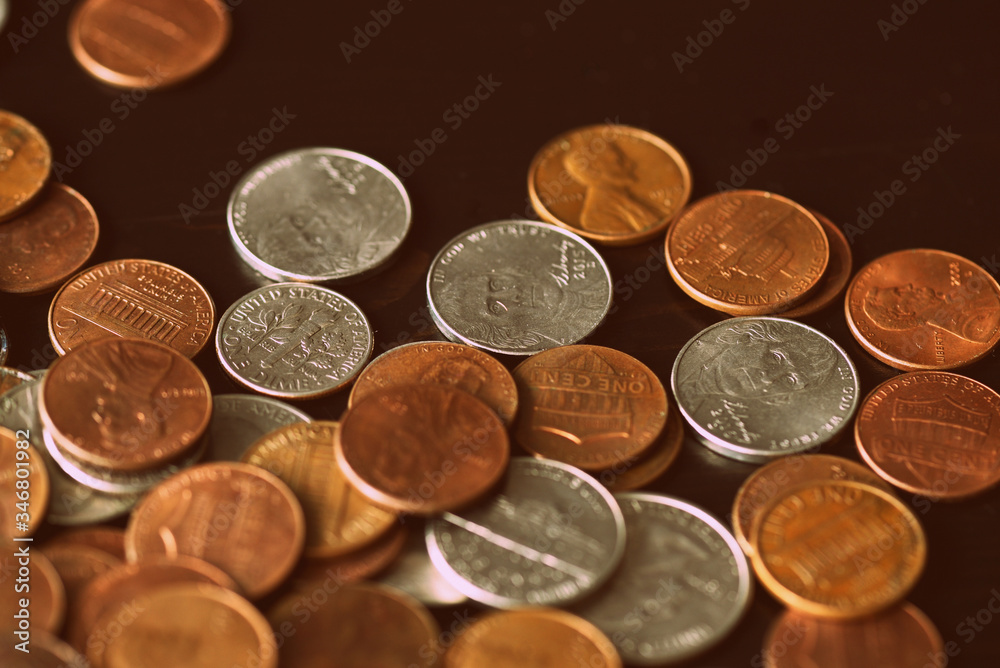 American cents are scattered on an old black wooden surface close-up. Retro style toned American cents are scattered on an old black wooden surface close-up. Retro style toned