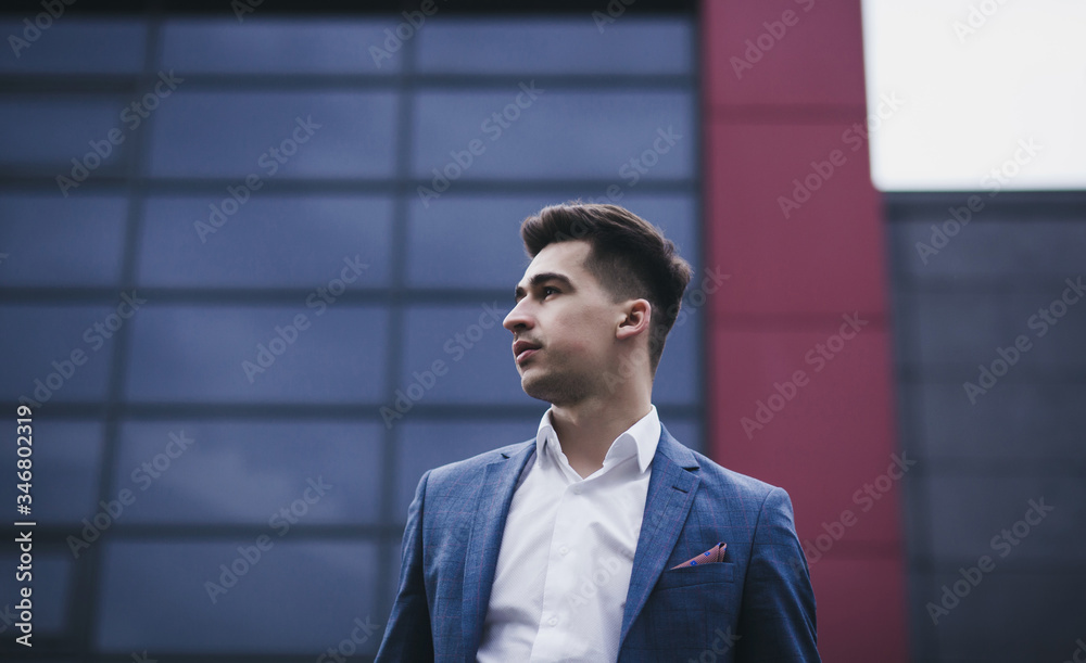 Portrait of young trendy man in suit posing in city background Portrait of young trendy man in suit posing in city background