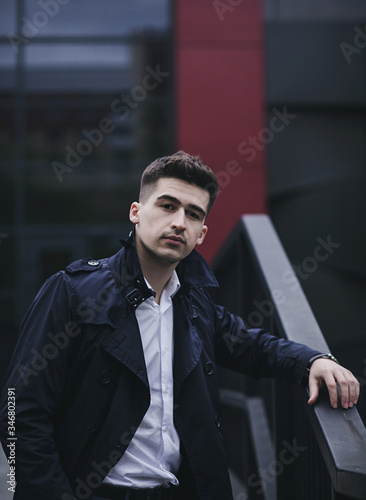 Canvastavla Handsome young man in suit and coat posing in city