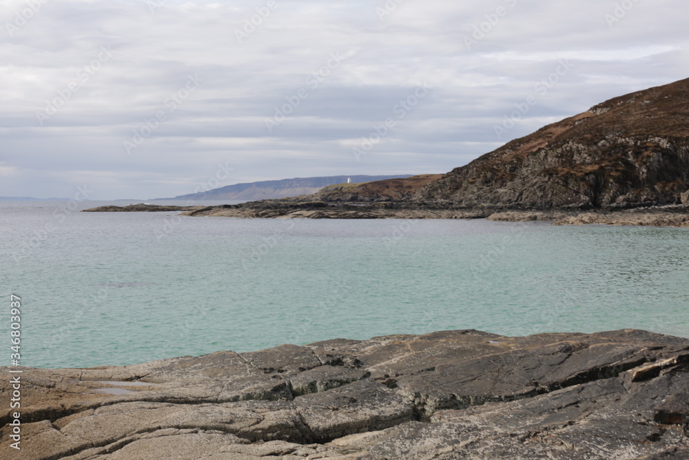 Crystal blue waters and a rugged coastline. 