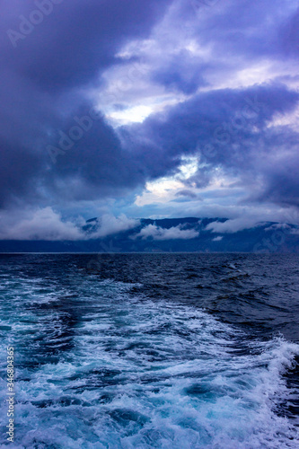 Storm clouds and raging waves in the sea in the evening during a storm in winter.