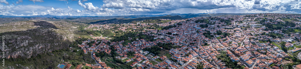 Aerial view panorama with sunshine, shadow, white clouds, rain shower and blue sky of the of historic town Diamantina and mountains, Minas Gerais, Brazil