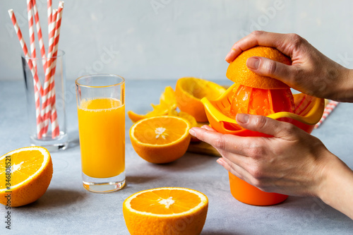 woman make orange juice home. female hands. haelthy food photo