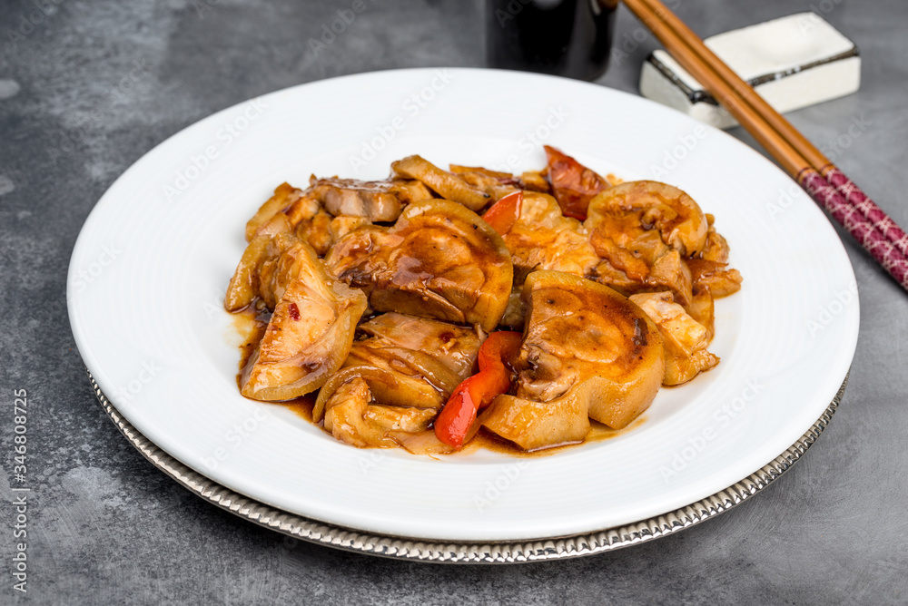 Fried shank in soy sauce served in a round white plate Fried shank in soy sauce served in a round white plate