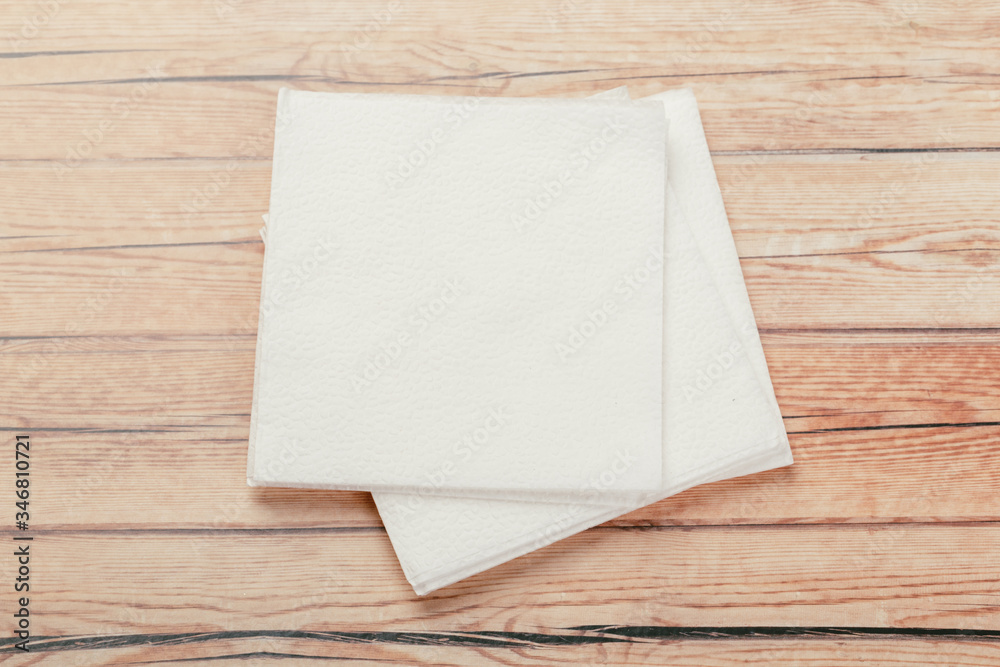 white paper napkin or tissue on the wooden table background. white paper napkin or tissue on the wooden table background.