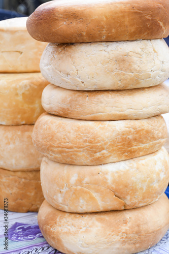 A variety of wheels of cheese seasoned with herbs for sale at the deli counter in the supermarket. photo