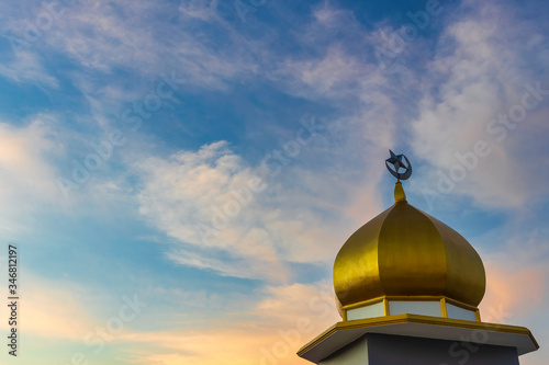 The golden dome with the symbol of Islam is the crescent moon and star under the beautiful sky in the morning.