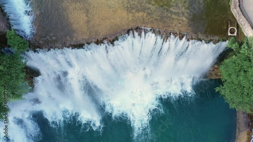 Medium wide angle dolly in drone shot of Provalije Waterfall in the pocitelj castle, Mostar city during the day photo