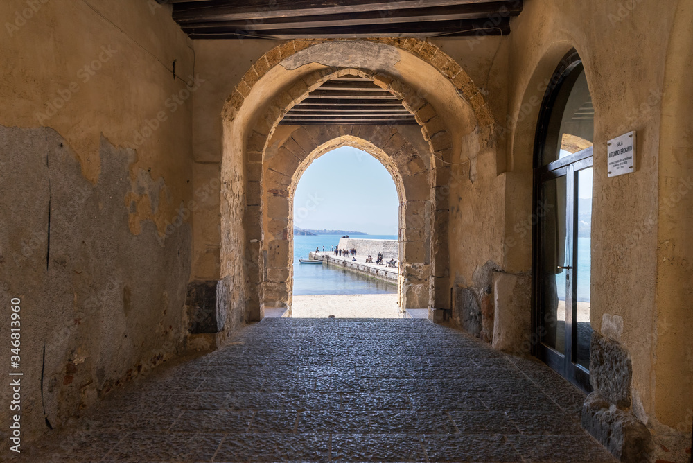 View to the old harbour and beach from Porta Pescara fishermen's gate on a sunny day in Cefalu, Sicily, Southern Italy.