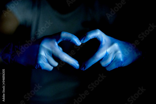 hands with heart-shaped gloves with black background