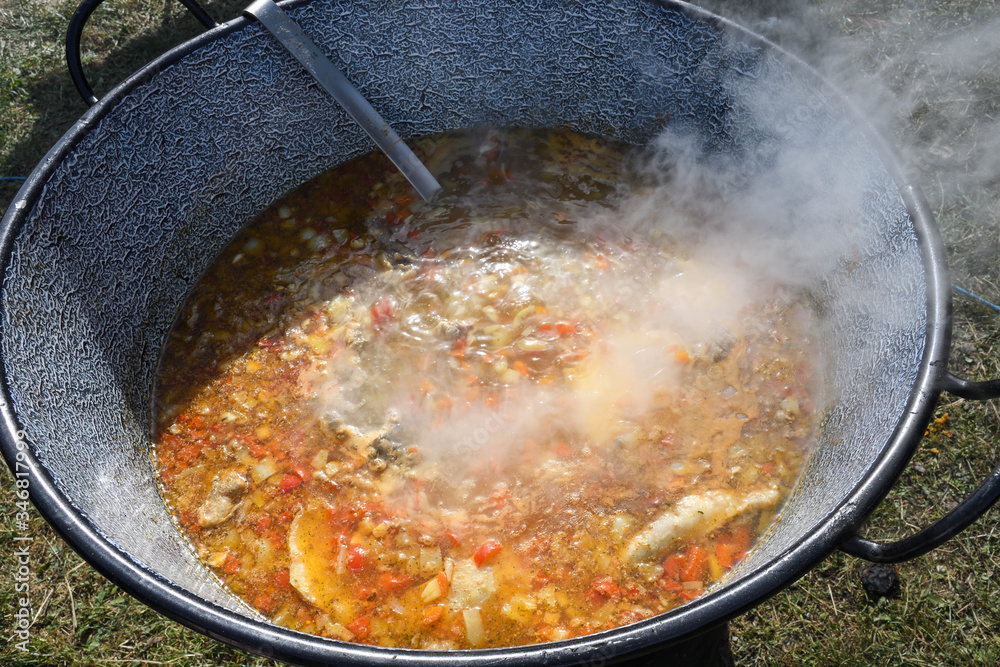 Very large cauldron cooking food during campfire. Cooking in a pot on the fire. Camping concept