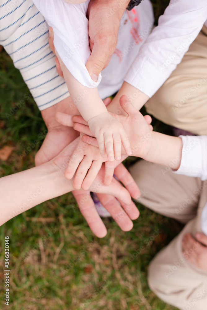 The family put their hands together. The hands of the whole family. The family's holding hands. The family put their hands together. The hands of the whole family. The family's holding hands.