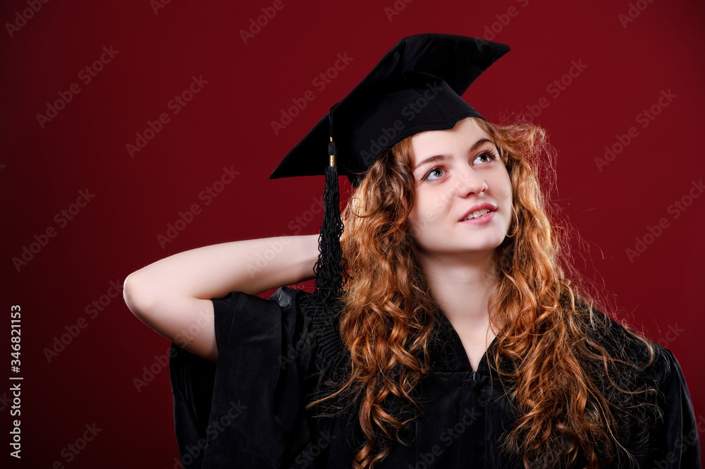 Female student in academic gown in red background Female student in academic gown in red background