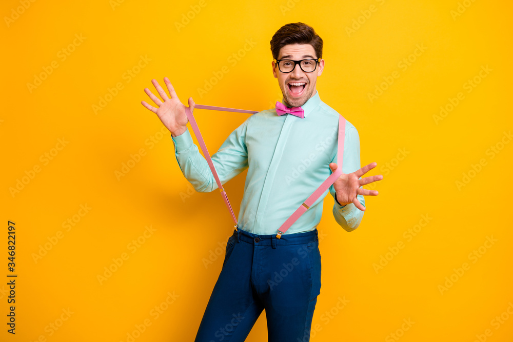 Photo of handsome cool clothes guy boyfriend hands hold stretch pink suspenders beaming smile festive mood wear specs shirt bow tie trousers isolated yellow color background Photo of handsome cool clothes guy boyfriend hands hold stretch pink suspenders beaming smile festive mood wear specs shirt bow tie trousers isolated yellow color background