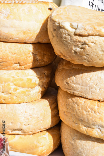 A variety of wheels of cheese seasoned with herbs for sale at the deli counter in the supermarket. photo