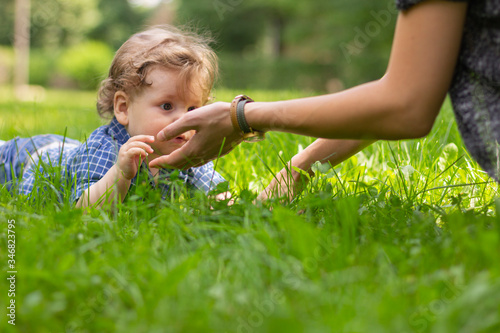Portrait of a little smiling boy outdoors. Smiling child on a green grass.