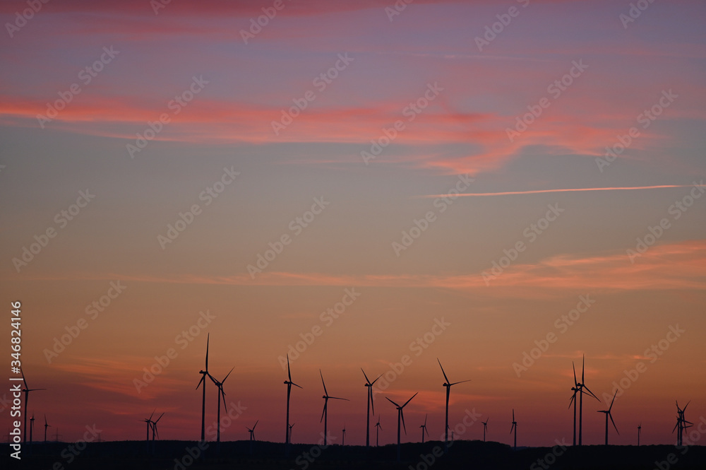 Windräder zur Stromerzeugung aus Windenergie am Horizont im Abendrot nach Sonnentungergang Windräder zur Stromerzeugung aus Windenergie am Horizont im Abendrot nach Sonnentungergang